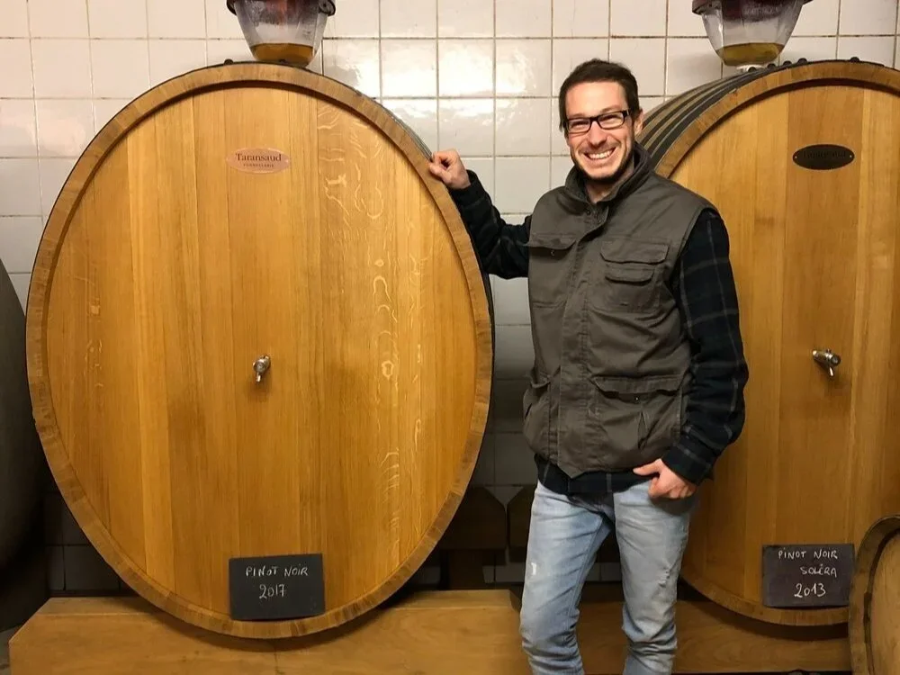 Adrien Renoir accanto ai foudres di Pinot Noir nella sua cantina a Verzy